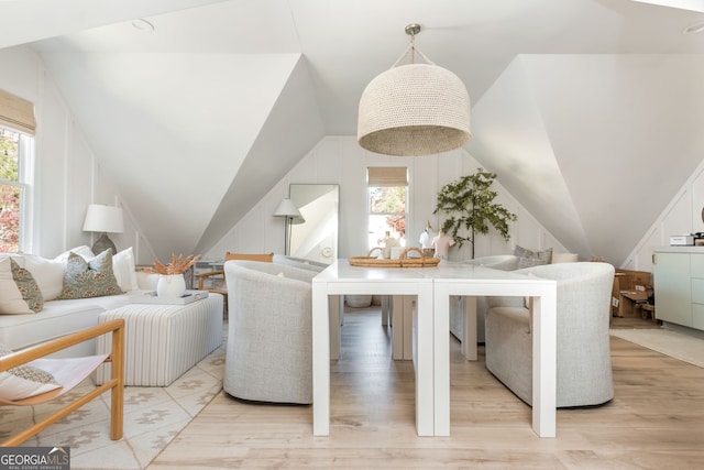 dining space with vaulted ceiling, a healthy amount of sunlight, and light wood-type flooring