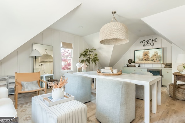 dining area featuring lofted ceiling and light hardwood / wood-style floors