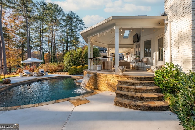 view of pool featuring pool water feature and a patio area