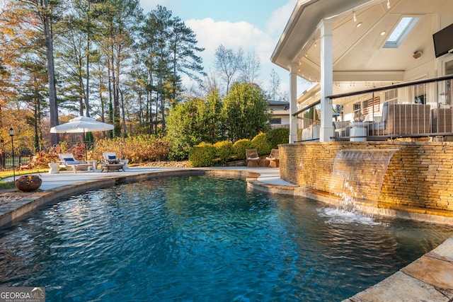 view of swimming pool with a bar, pool water feature, and a patio