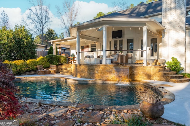 view of pool with pool water feature, ceiling fan, and a patio