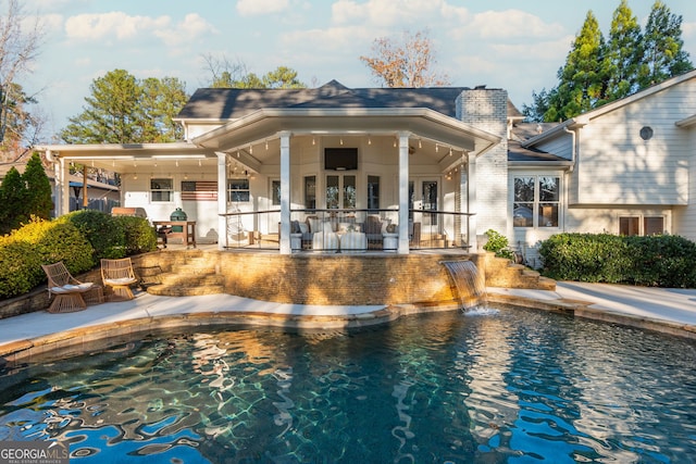 rear view of house featuring pool water feature, ceiling fan, and a patio area