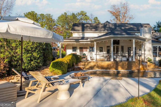 rear view of property with a patio and an outdoor fire pit