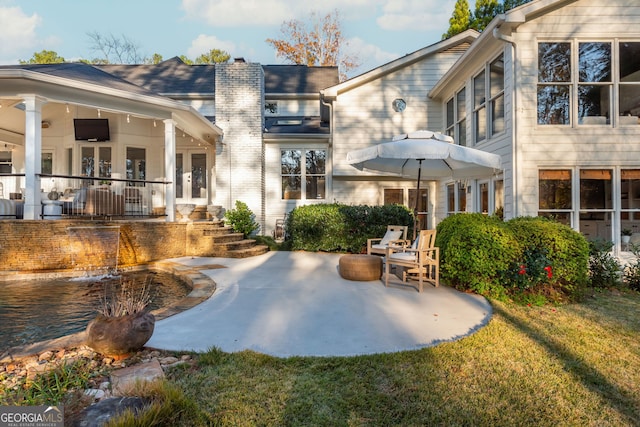 rear view of house featuring a yard and a patio area