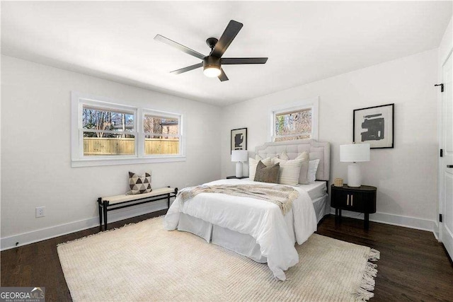 bedroom featuring ceiling fan, multiple windows, and dark hardwood / wood-style flooring