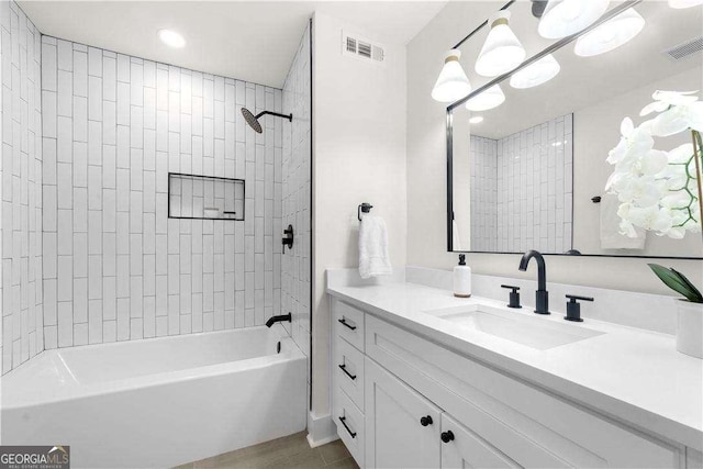 bathroom featuring vanity and tiled shower / bath