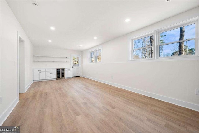 unfurnished living room featuring light hardwood / wood-style floors and indoor bar