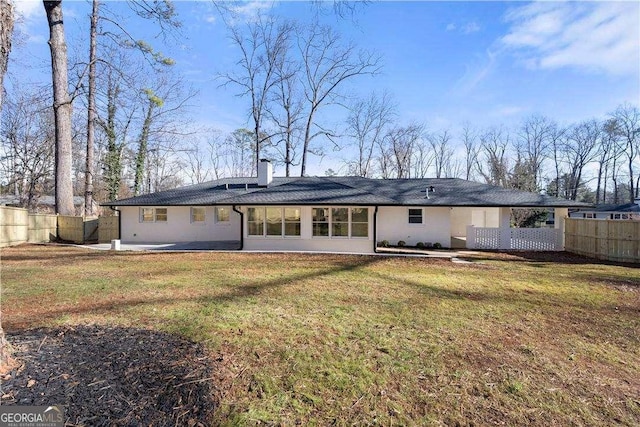 back of property featuring a lawn and a patio