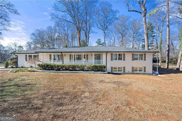 view of front of house with covered porch and a front lawn