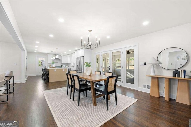 dining space with french doors, a chandelier, and dark wood-type flooring