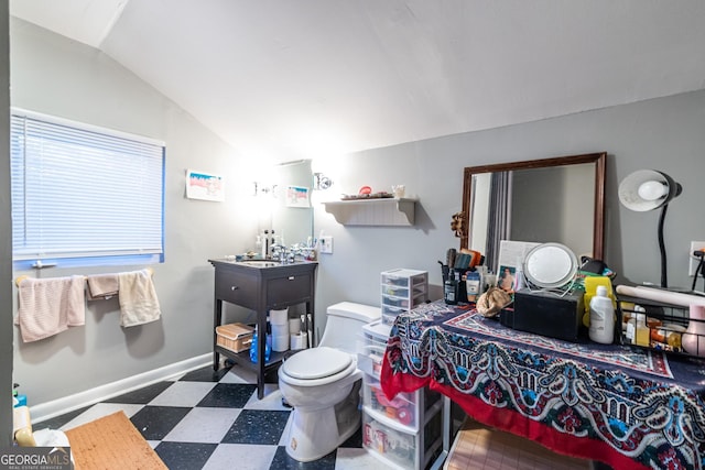 bathroom with sink, toilet, and vaulted ceiling