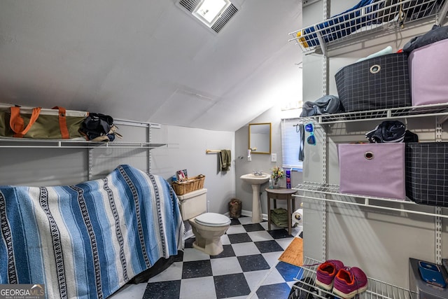 bathroom featuring sink, toilet, and vaulted ceiling