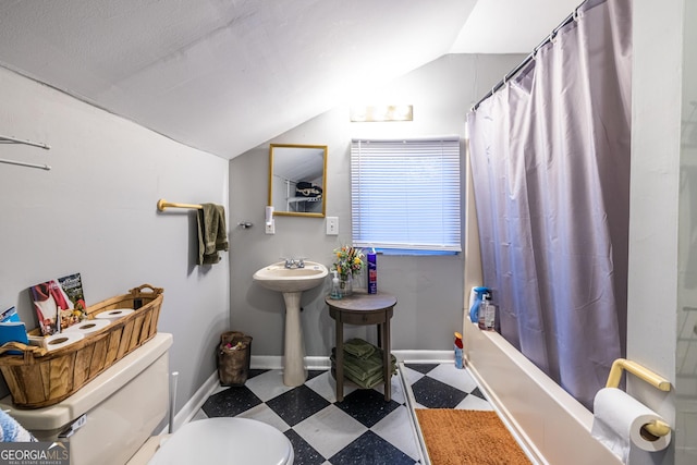 bathroom with vaulted ceiling, shower / tub combo, and toilet