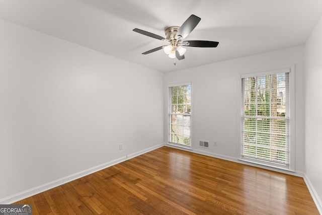 unfurnished room featuring visible vents, a ceiling fan, wood finished floors, and baseboards