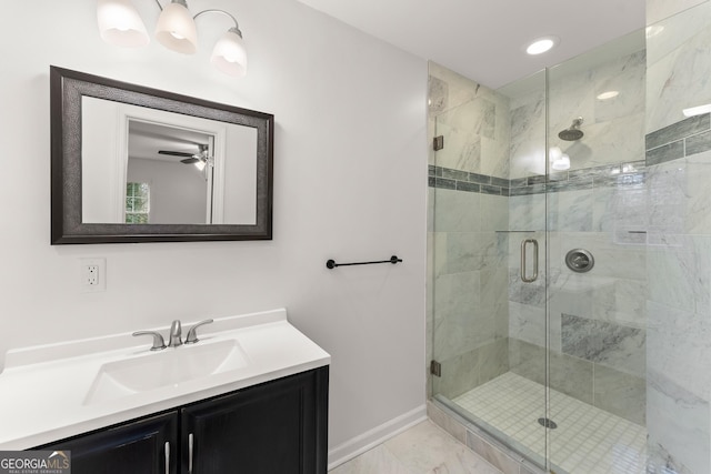 full bathroom featuring a stall shower, vanity, marble finish floor, and baseboards