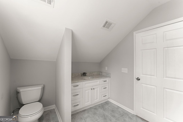 bathroom featuring vanity, baseboards, visible vents, toilet, and vaulted ceiling