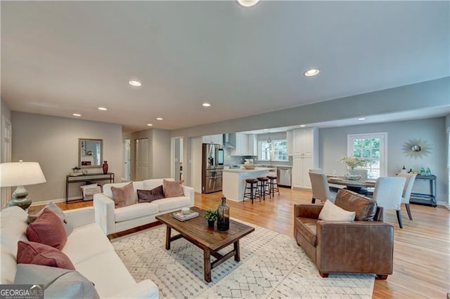 living room with baseboards, light wood-style floors, and recessed lighting