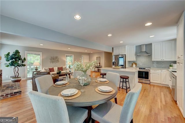 dining room featuring light wood-type flooring, recessed lighting, and baseboards