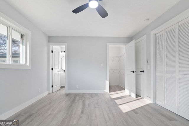 unfurnished bedroom featuring light wood-type flooring, ceiling fan, and ensuite bath