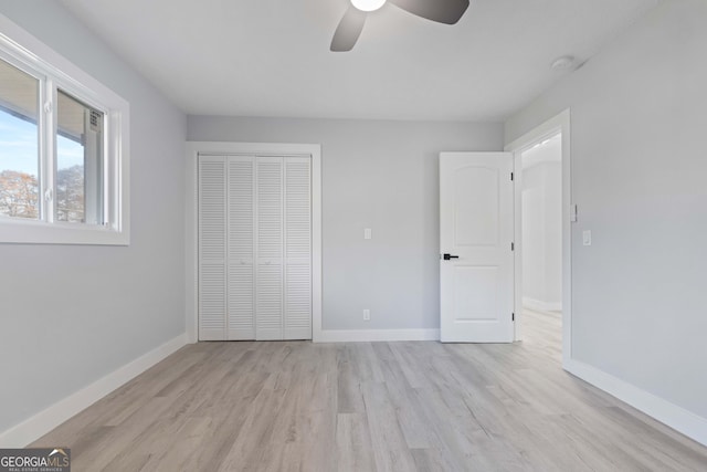 unfurnished bedroom with ceiling fan, a closet, and light hardwood / wood-style flooring