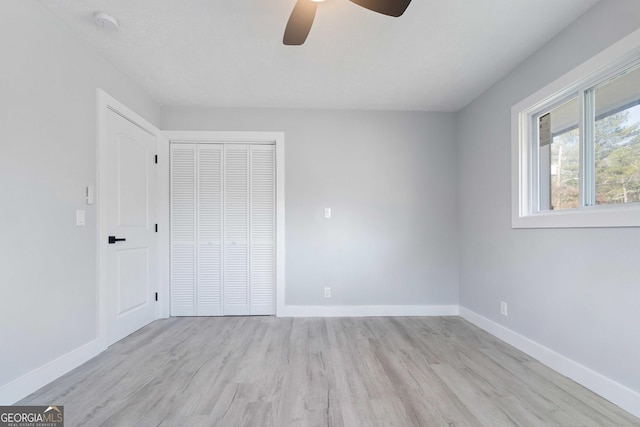 unfurnished bedroom featuring light hardwood / wood-style floors, a closet, and ceiling fan