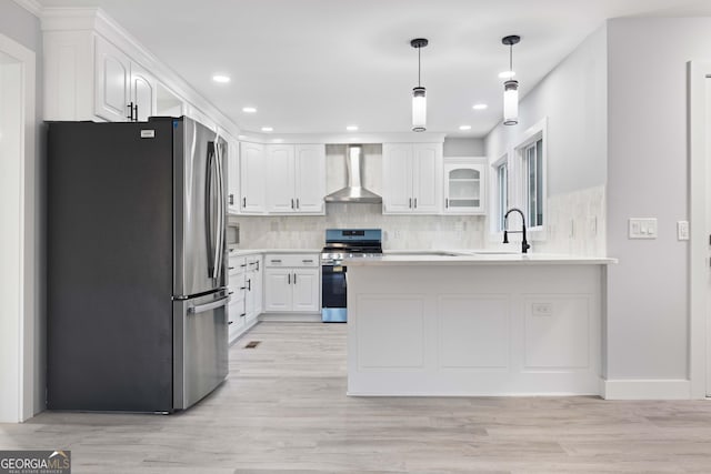 kitchen featuring white cabinetry, sink, wall chimney range hood, and appliances with stainless steel finishes