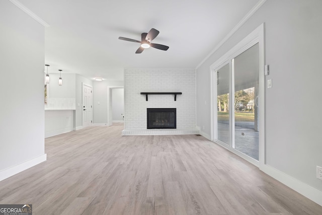 unfurnished living room featuring ceiling fan, a brick fireplace, crown molding, and light hardwood / wood-style floors