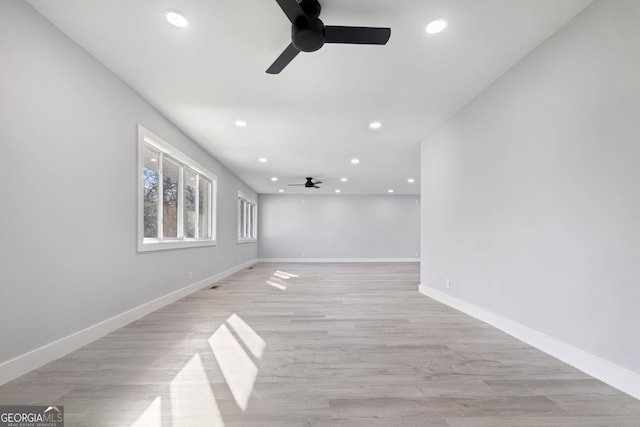 empty room with ceiling fan and light hardwood / wood-style flooring