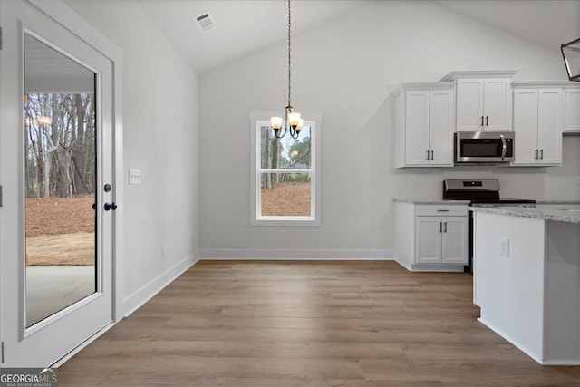 kitchen with an inviting chandelier, hanging light fixtures, light hardwood / wood-style flooring, light stone countertops, and white cabinets