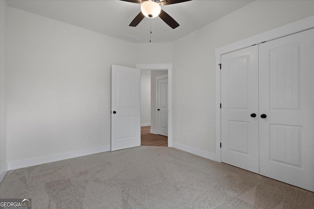 unfurnished bedroom with ceiling fan, carpet flooring, and a closet