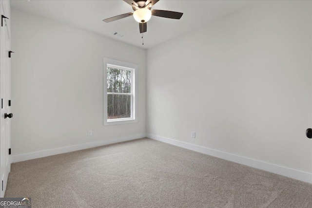 carpeted spare room featuring ceiling fan