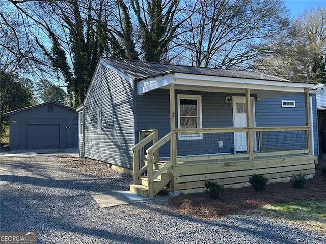 view of front of house featuring a garage, an outbuilding, and a porch