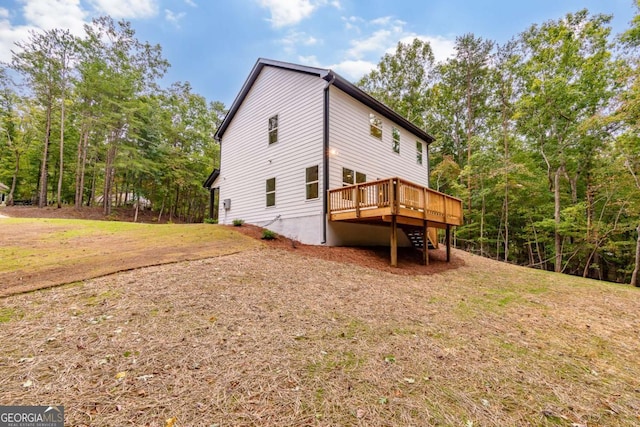 view of side of home featuring a wooden deck and a yard