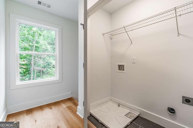 laundry area with hardwood / wood-style flooring, hookup for a washing machine, and hookup for an electric dryer