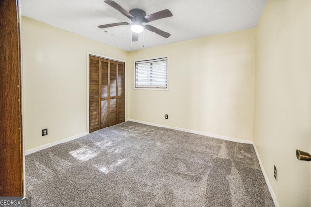 unfurnished bedroom featuring ceiling fan, carpet, and a closet