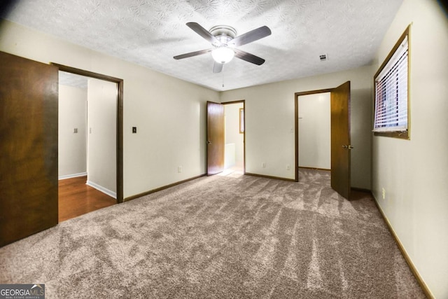 unfurnished bedroom featuring ceiling fan, a textured ceiling, and carpet floors