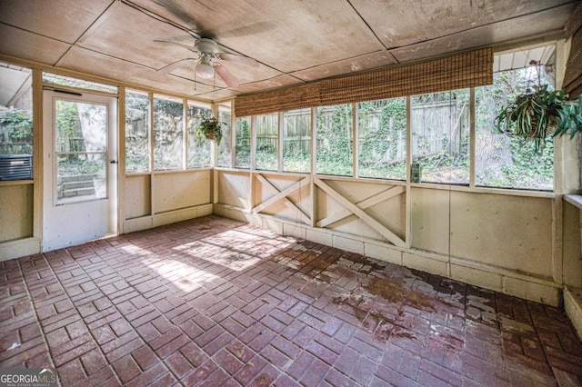 unfurnished sunroom with ceiling fan