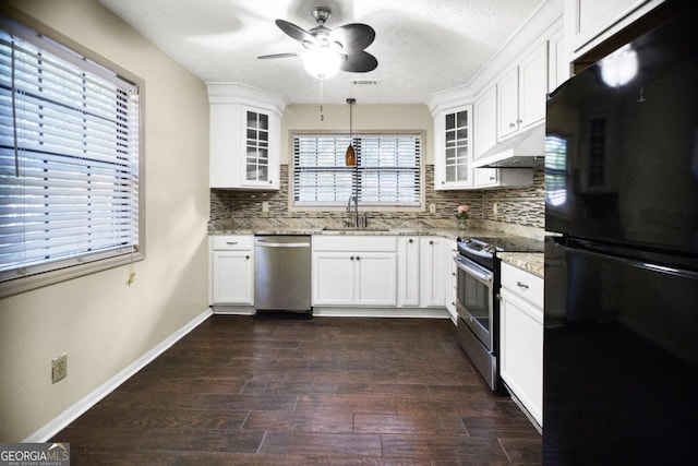kitchen featuring sink, backsplash, dark wood-type flooring, white cabinets, and stainless steel appliances