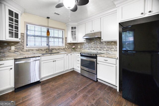 kitchen with tasteful backsplash, hanging light fixtures, white cabinets, sink, and stainless steel appliances