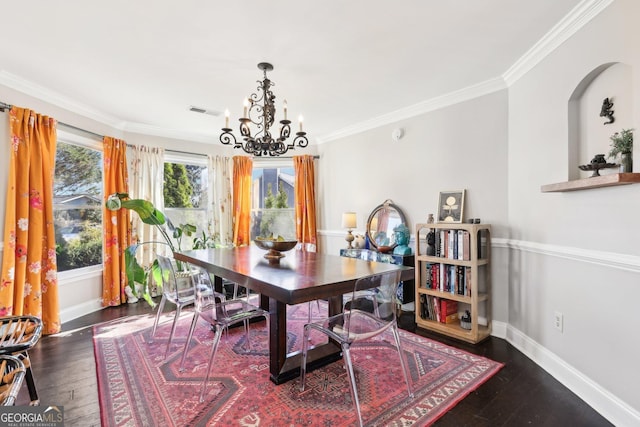 dining room featuring crown molding, dark hardwood / wood-style floors, and an inviting chandelier