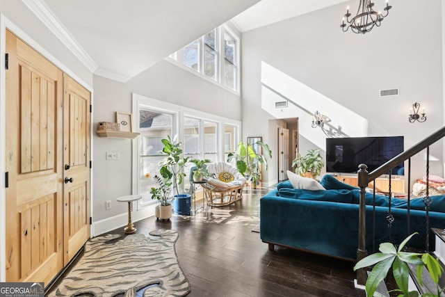 living room featuring dark hardwood / wood-style floors, crown molding, and a notable chandelier