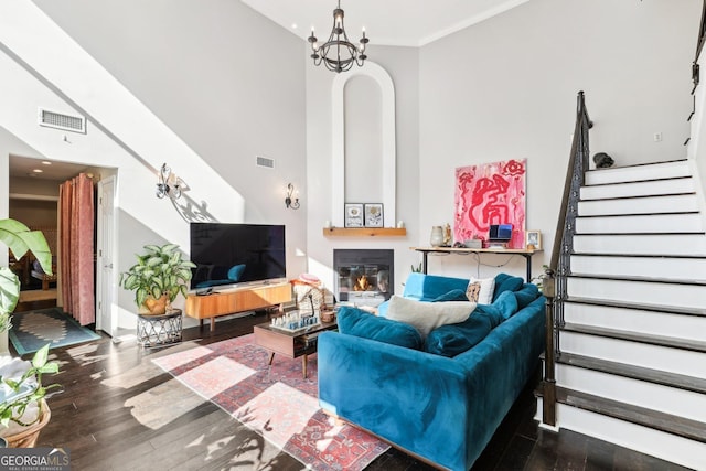 living room featuring a chandelier, hardwood / wood-style floors, and crown molding