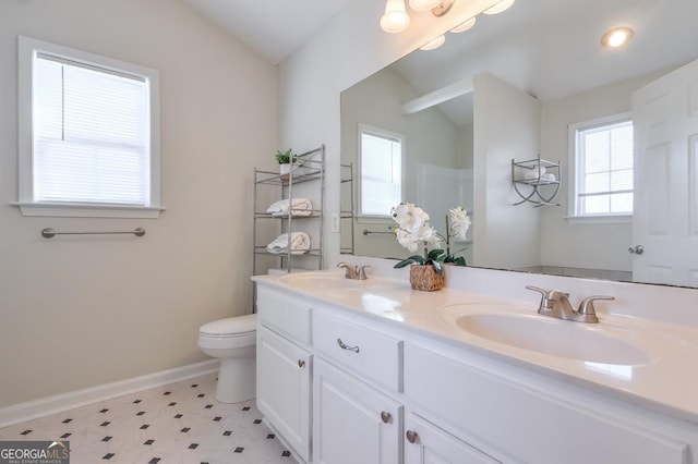 bathroom with vanity, lofted ceiling, and toilet