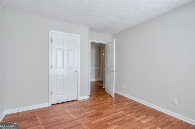 unfurnished bedroom featuring light hardwood / wood-style floors and a textured ceiling