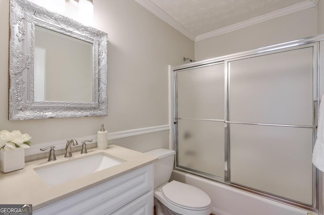 full bathroom with enclosed tub / shower combo, vanity, toilet, crown molding, and a textured ceiling