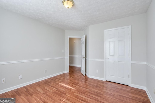 unfurnished bedroom with a textured ceiling and light wood-type flooring