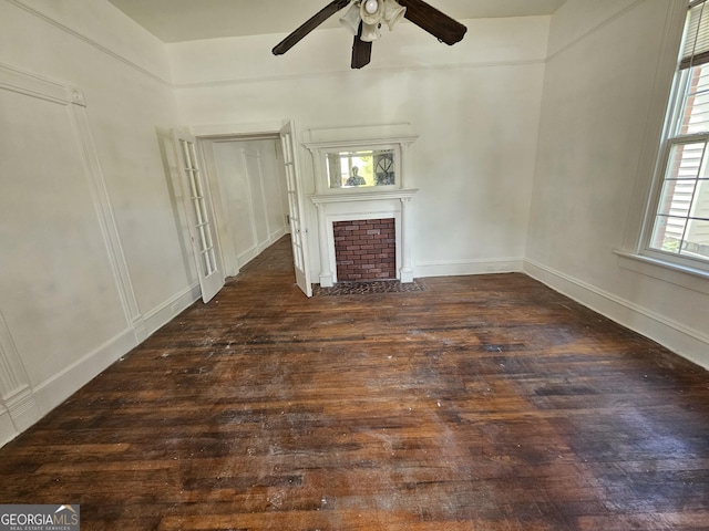 unfurnished living room with ceiling fan, dark hardwood / wood-style floors, and a fireplace