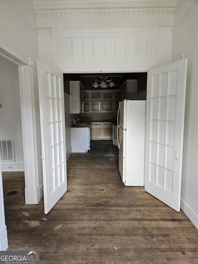 hall with sink, dark wood-type flooring, and lofted ceiling