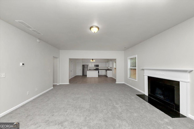 unfurnished living room featuring light carpet