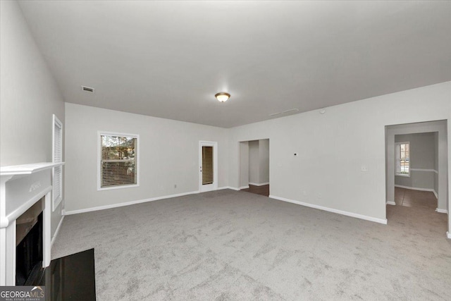 unfurnished living room with a wealth of natural light and carpet flooring